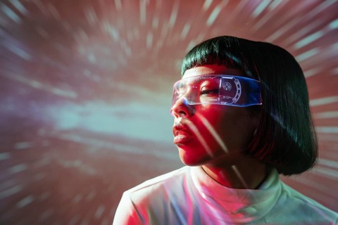 Latin woman immersed in the virtual world, wearing advanced futuristic virtual reality glasses with