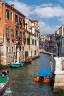 Venetian canal with beautiful old buildings and boats in sunny weather, Venice, Italy
