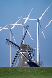 Poldermolen De Goliath windmill stands between the high-tech wind turbines in Eemshaven, historic