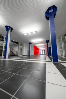 Modern interior with blue columns, red wall and tiled floor, University of Stuttgart, Germany
