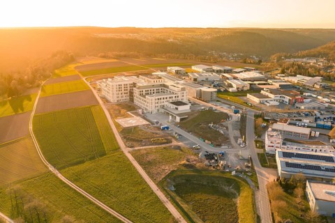 Industrial area and building complex in a hilly landscape photographed from the air at sunset, new