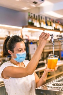 Photo session with a waitress with a face mask in a bar. New normality, security measures after the