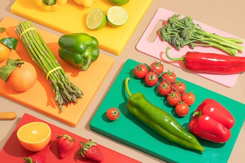 A colorful and artistic display of fresh vegetables and fruits on vibrant cutting boards. Includes
