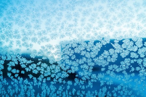 Close-up of intricate ice crystal formations on a window in Swedish Lapland, showcasing nature's