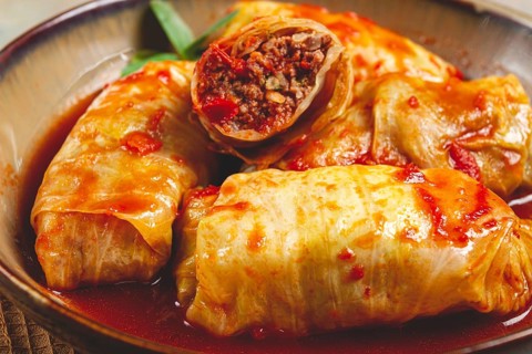 Stuffed cabbage rolls with minced meat, in tomato sauce, top view, without people, in the spotlight