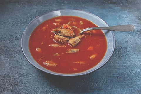 French shrimp bisque soup, in a plate, on a blue background, close-up, no people