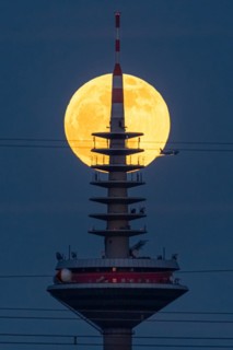The full moon passes behind the top of the Europaturm in Frankfurt am Main, Frankfurt am Main,