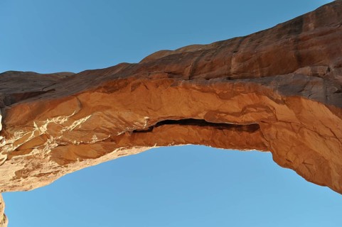 Natural sandstone arch rises majestically against a blue sky, Arches National Park, Utah, USA