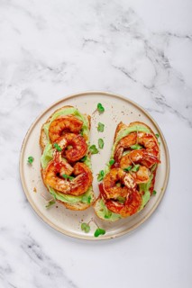 Sandwiches with avocado and caramelized shrimp, micro-greens, breakfast, on a plate, top view,