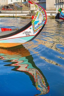 Traditional Moliceiro boat reflected in the water, Aveiro, Portugal