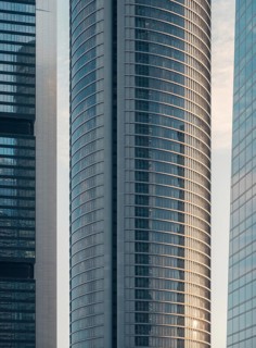 A close-up view of sleek, modern skyscrapers in downtown. The glass and steel structures reflect