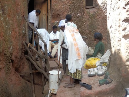 Group of people take off their shoes in front of entering a rock church, UNESCO World Heritage