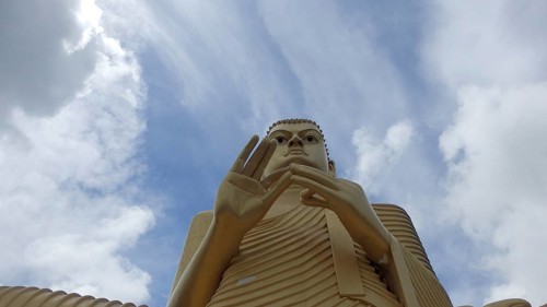 Impressive Buddha sculpture against a cloudy sky, Dambulla, Sri Lanka
