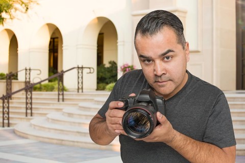 Hispanic Young Male Photographer With DSLR Camera Outdoors
