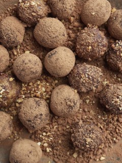 Close up view of chocolate bliss balls dusted with cacao and nuts. Sugar free truffles or energy