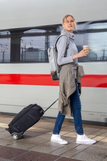 Young woman on the railway track while a train arrives