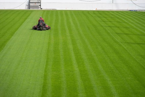 Mowing grass at the football stadium in Lubin, Poland