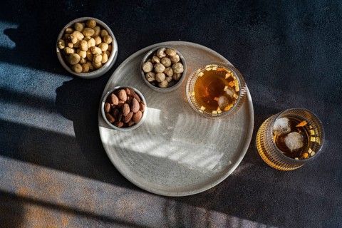 Top view of a rich spiced cognac cocktail accompanied by cinnamon, anise star, and assortments of