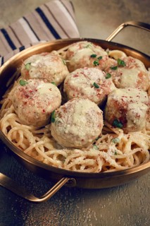 Spaghetti with chicken meatballs, with cream sauce, and parmesan cheese, and decorated with