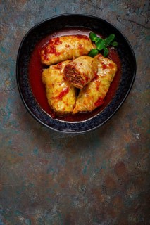 Stuffed cabbage rolls with minced meat, in tomato sauce, top view, without people, in the spotlight