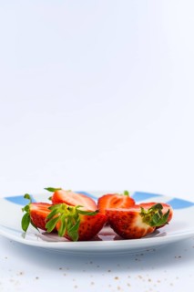 Strawberries cut into a white plate with a white background with brown sugar