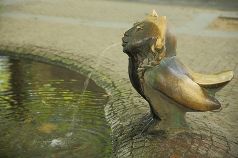 European fountain by Gernot Rumpf 1980, mythical creatures, fantasy creature, owl figure with face
