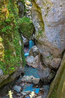 Turquoise water flows through the narrow rocky gorges of the tolmin gorges natural reserve in