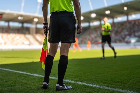 Legs of football sideline referee and main referee in the background in Lubin, Poland