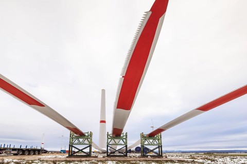 Rotor blades lying in front of the unfinished tower at the Cramme wind farm construction site,