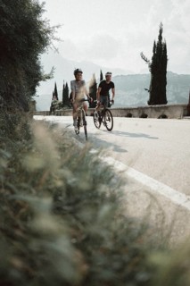 Woman and man riding racing bikes in Italy on Lake Garda