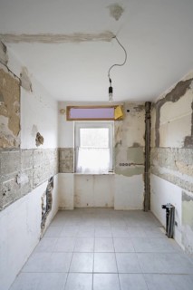 Apartment is being renovated, partly exposed walls, exposed pipes, old building renovation