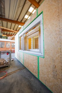 Wooden wall with prepared window opening in a factory building, modern construction, façade