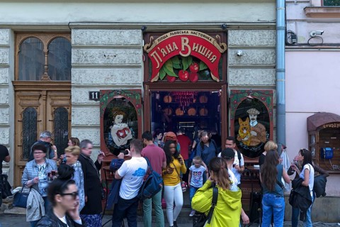 Young people having drinks in front of a tavern, Lviv, Ukraine