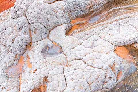 This image features abstract patterns of white rocks cracked by geological processes, with striking