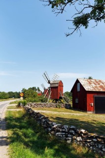 Red trestle windmills on the side of the road, limestone dry stone walls, Lerkaka, Öland island,