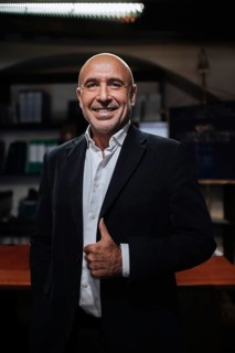 A confident professional in a suit poses in a sophisticated office. The setting conveys leadership