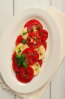 Caprese salad, Italian traditional dish, tomatoes with mozzarella cheese, basil and spices, top