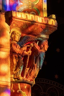 Issoire. Pillar (The Annunciation made to Mary) . The figures are illuminated by colorful light