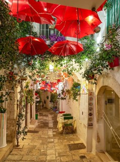 Narrow street in Ostuni lit by street lights at night, Apulia - Puglia, Italy