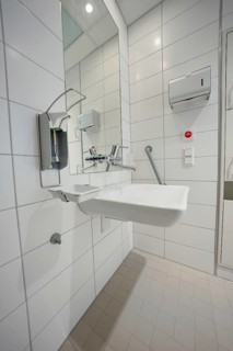 Modern hospital bathroom with sink and sterile tiled design, patient room cash desk in the new Calw