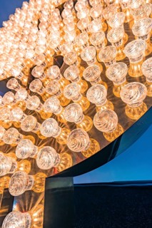 Close-up of light bulbs arranged in the shape of a dollar sign with a shiny, detailed effect,
