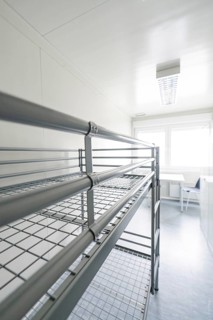 Simple room with a metal bunk bed and lots of natural light, Beermiß refugee accommodation,