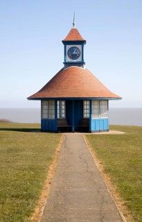 Seaside shelter and clock tower by the sea on the Greensward, Frinton on Sea, Essex, England,