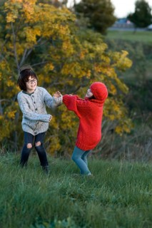 In a lush park during Autumn, two siblings, a girl and a boy, enjoy playful moments surrounded by