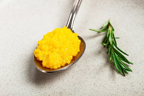 Yuzu caviar is pearly, on a spoon, top view, light background, no people