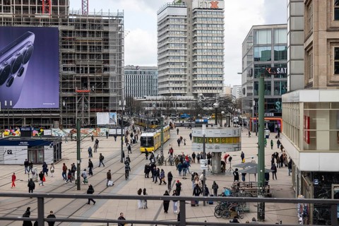 View of Alexanderplatz in Berlin with people and world clock. Tram Covivio Tower construction site.