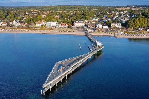 Aerial view over Seebrücke, pier and sandy beach at seaside resort Haffkrug along the Baltic Sea,