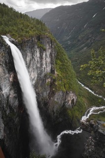 A breathtaking view of a mighty waterfall cascading down verdant cliffs in Norway's stunning
