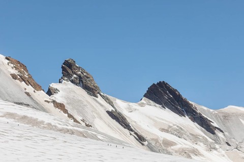 A stunning panoramic view of the Zermatt Alps in summer, showcasing rugged mountain peaks under a