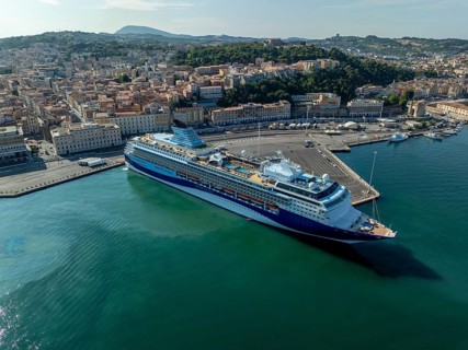Aerial view of a large ocean liner docked at the bustling port, Italy, with the city's historic